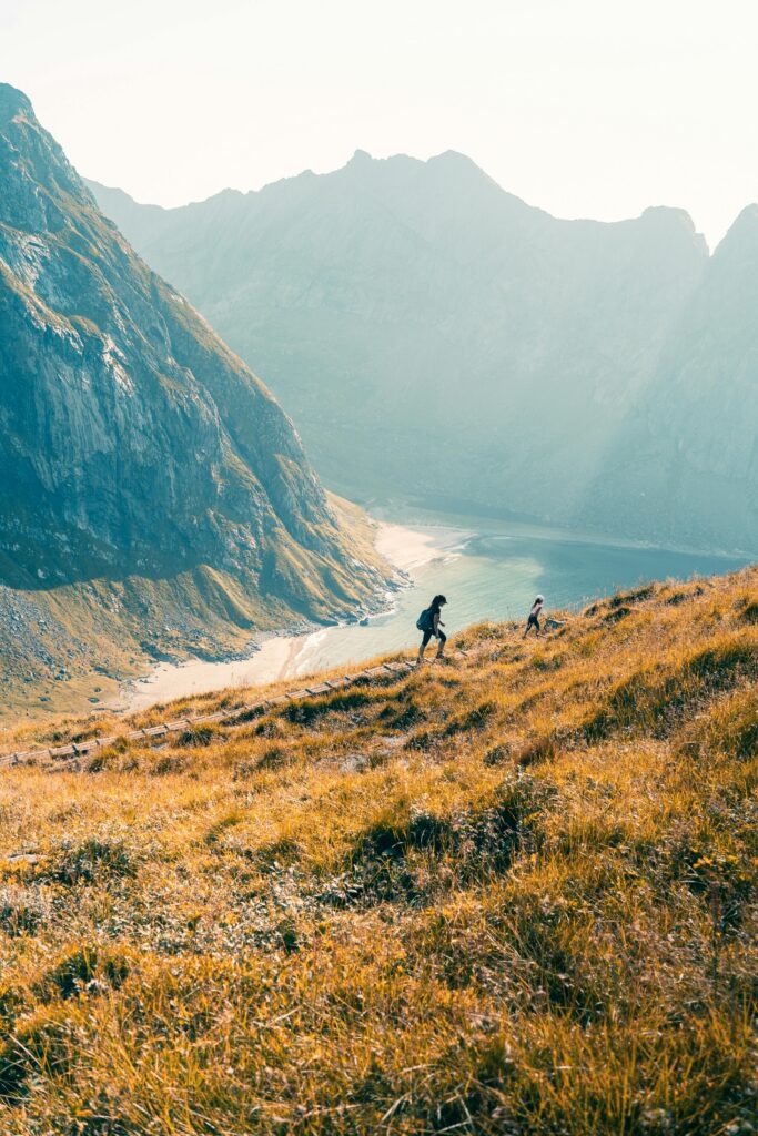 Two hikers explore the stunning landscapes of Fredvang, Norway.